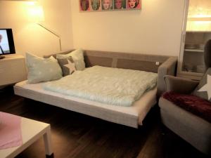 um quarto com uma cama, um sofá e uma televisão em Ostseeblick em Scharbeutz