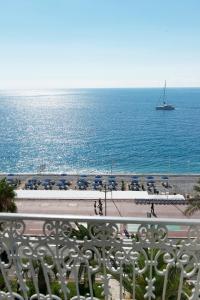 a view of a beach with a boat in the water at Hôtel West End Promenade in Nice