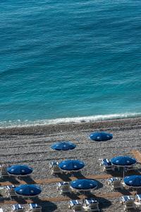 a group of chairs and umbrellas on a beach at Hôtel West End Promenade in Nice