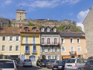 um grupo de edifícios com um castelo ao fundo em Au Pied du Chateau em Lourdes