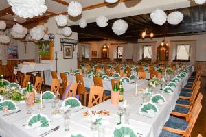 un gran salón de banquetes con mesas y sillas blancas en Gasthof Oberer Gesslbauer en Stanz Im Murztal