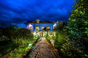 a large blue house with lights on it at night at El Búho de la Remolina in Bode