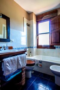 a bathroom with a toilet and a tub and a sink at El Búho de la Remolina in Bode