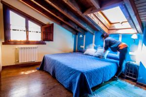 a man is jumping on a bed in a room at El Búho de la Remolina in Bode