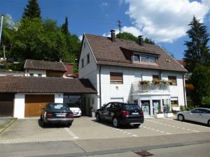 dos autos estacionados en un estacionamiento frente a un edificio en Ferienwohnung Behrens-Reinke, en Albstadt