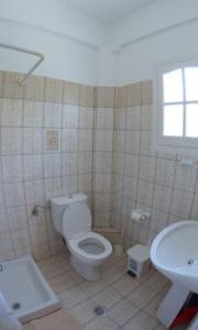 een badkamer met toilet en wastafel bij Villa Leonidas in Agios Stefanos