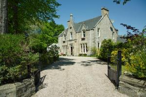 an old house with a gate and a driveway at Ravenscourt House, Guest House & Restaurant in Grantown on Spey