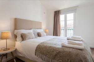A bed or beds in a room at Chiado River View Deluxe Apartment