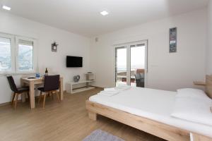 ein weißes Schlafzimmer mit einem Bett, einem Schreibtisch und einem Tisch in der Unterkunft Villa Sara with Sea View and Private Heated Pool in Omiš