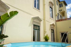 a swimming pool in front of a building at La Palma Hostel Leiria in Leiria