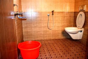 La salle de bains est pourvue de toilettes et d'un seau rouge. dans l'établissement Club 7 Beach Resort, à Kannur 45 autres photos