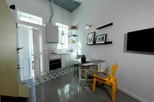 a kitchen with a table and a tv on the wall at DUBOCAGE43 Citycenter in Faro