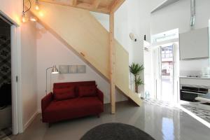 einen roten Stuhl im Wohnzimmer mit einer Treppe in der Unterkunft DUBOCAGE43 Citycenter in Faro