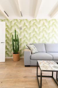 een woonkamer met een bank en een cactus bij Fruit of the City - R.Q.C. in Den Haag