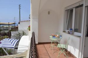 een patio met een tafel en stoelen op een balkon bij Casa L'Agave in Capri