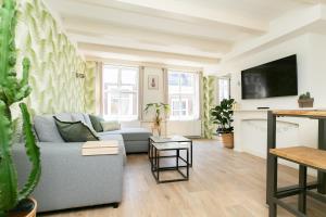 een woonkamer met een bank en een tv bij Fruit of the City - R.Q.C. in Den Haag