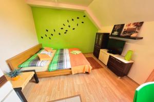 a bedroom with a green wall with birds on the wall at Apartmán Donovaly in Donovaly