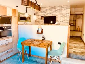 a kitchen with a wooden table and blue chairs at DT Loft in Puerto Natales