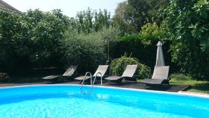 una piscina con 4 sillas y una sombrilla en Villa Ester, en Rovinj