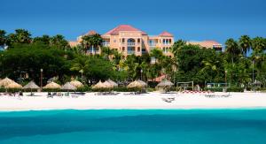a resort on a beach with umbrellas and the water at Divi Village Golf and Beach Resort in Palm-Eagle Beach