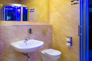 a bathroom with a sink and a toilet and a mirror at Hotel Holiday Park in Warsaw