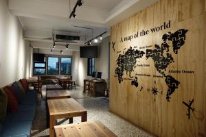 
a wooden table with a mural on the wall at Cao Ji Book Inn Hostel in Tainan
