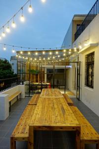 a large wooden table on a patio with lights at Cao Ji Book Inn Hostel in Tainan