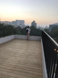 a woman walking on a boardwalk over a city at Cao Ji Book Inn Hostel in Tainan