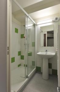 uma casa de banho com um lavatório e uma cabina de duche em vidro. em L'Inattendu em Le Vernet