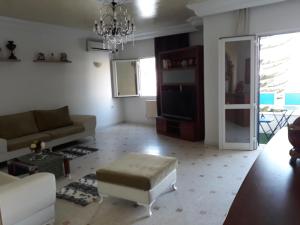 - un salon avec un canapé et une table dans l'établissement Superbe Appartement bord de mer, à Sousse