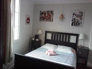 Un dormitorio con una cama con un juguete rosa. en L'Ex-Voto, en Honfleur