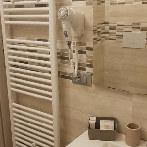a bathroom with a hair dryer on a wall at Quarantotto B&B in Raffa