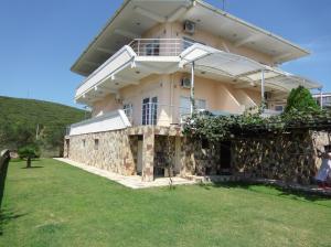 ein großes Haus mit einer Steinmauer in der Unterkunft Villa Daniela Apartments in Nov Dojran
