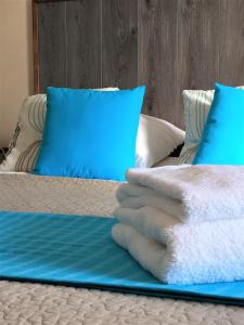 a bed with blue pillows and a blue blanket at La Belle Verte in Pornic