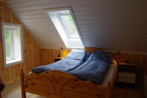 a bed with a blue comforter in a room at Lunheim in Geiranger in Geiranger