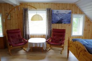 a bedroom with two chairs and a table and a bed at Lunheim in Geiranger in Geiranger