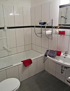 uma casa de banho com uma banheira, um WC e um lavatório. em Hotel zum Zauberkabinett em Bad Heilbrunn