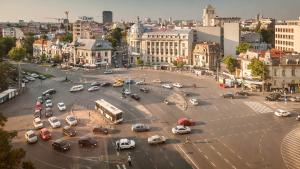 a busy city street with cars and a bus at Retro MidTown Apartment in Bucharest
