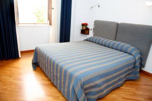 a bed with a blue and white striped blanket in a room at Il Peschio in Pescocostanzo
