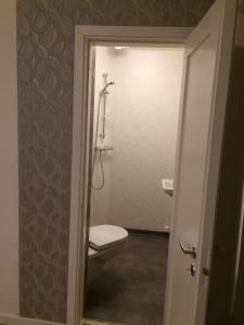 uma casa de banho com um WC e um chuveiro em Mittes Rum em Alingsås