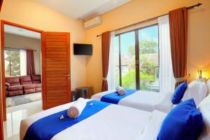 a bedroom with two beds and a large window at Villa Alessandra Seminyak By Bali Asia Villa in Seminyak +39 photos