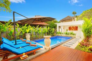 a pool with two blue lounge chairs and an umbrella at Villa Alessandra Seminyak By Bali Asia Villa in Seminyak