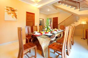 a dining room with a table and chairs and stairs at Villa Alessandra Seminyak By Bali Asia Villa in Seminyak