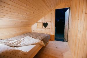 um quarto com uma cama num quarto de madeira em Alp Glamping Village em Radovljica