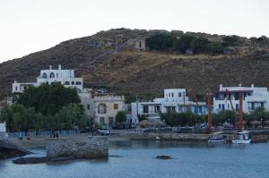 a group of white buildings with a hill in the background at Limnes Home in Moutsoúna