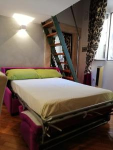 uma cama num quarto ao lado de uma escada em Cà Ro - Casa Rosetta "Tiny house" em Tivoli