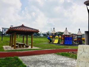 うるま市にあるエムスリーのベンチとパビリオンのある遊び場のある公園