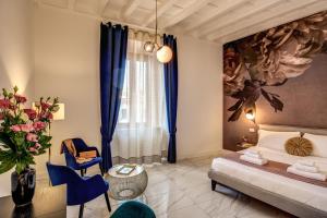 a bedroom with a bed and a vase of flowers at Little Queen Pantheon in Rome