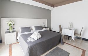 1 dormitorio con 1 cama y 1 mesa con sillas en Hotel Giulia Ocean Club, en Qualiano