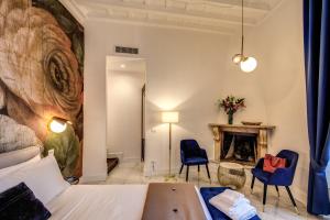 a room with a bed and two chairs and a fireplace at Little Queen Pantheon in Rome